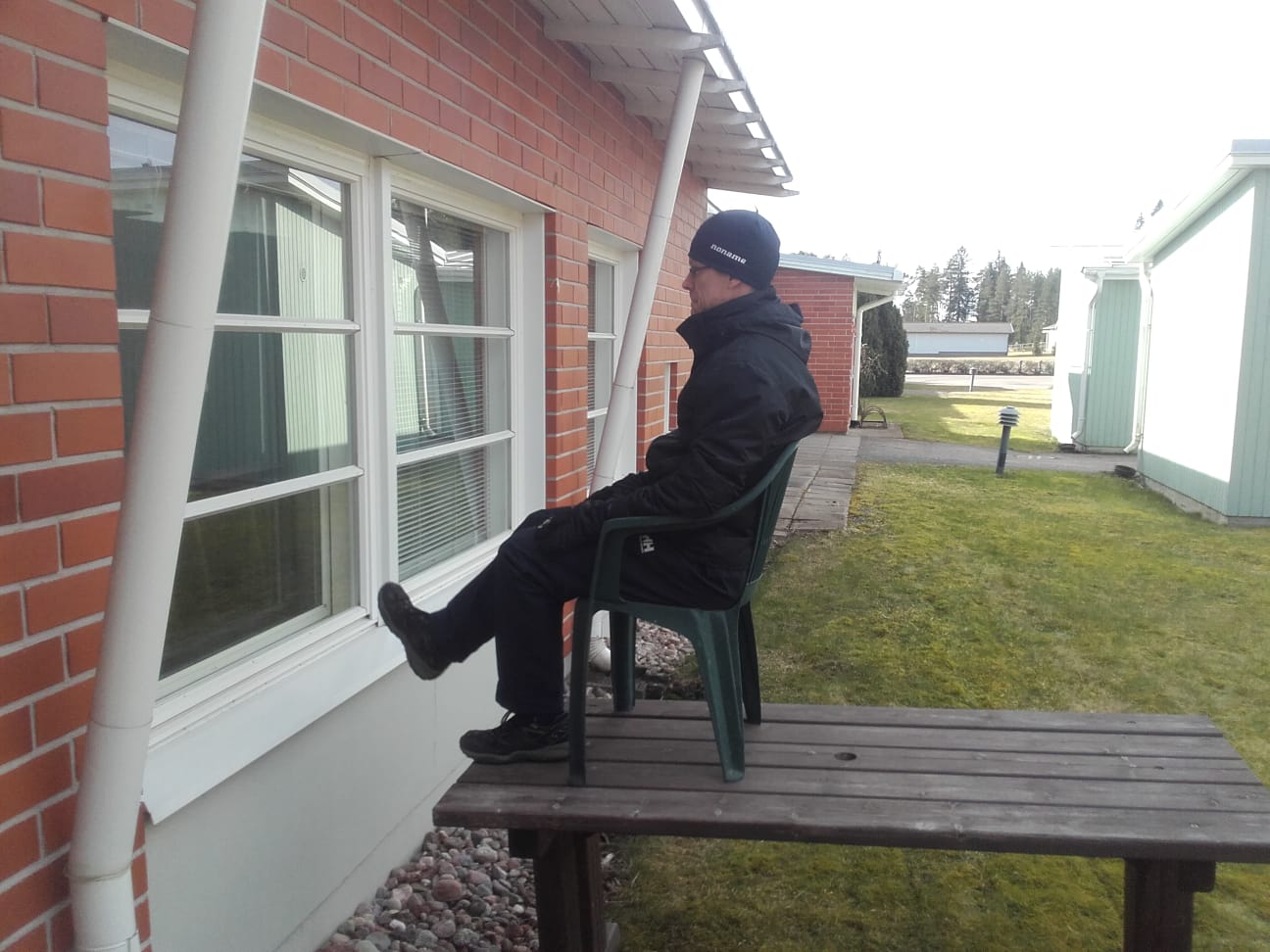 ohjaaja istuu ulkona tuolilla, joka on pÃ¶ydÃ¤n pÃ¤Ã¤llÃ¤